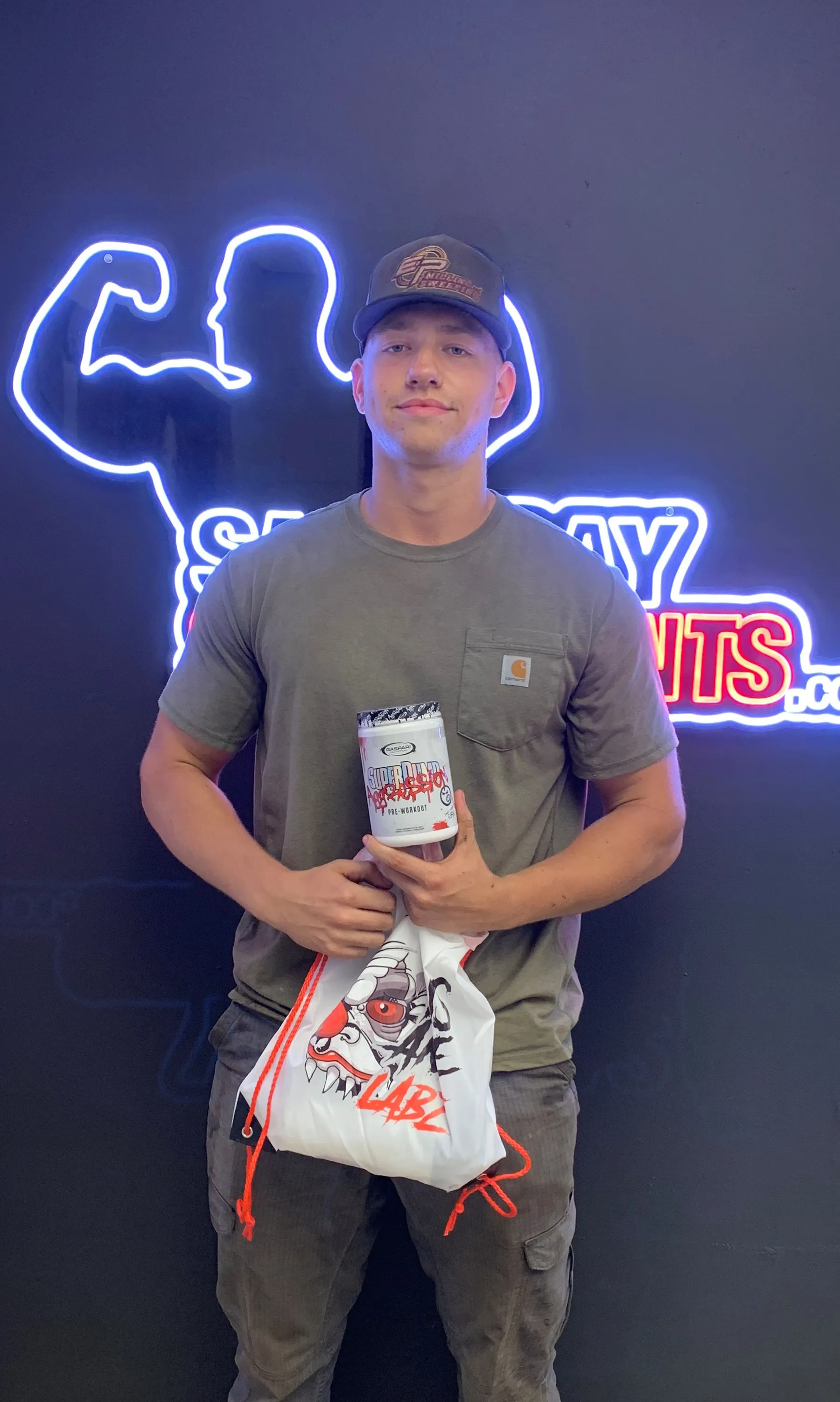 Customer holding Insane Labz drawstring bag and pre-workout tub