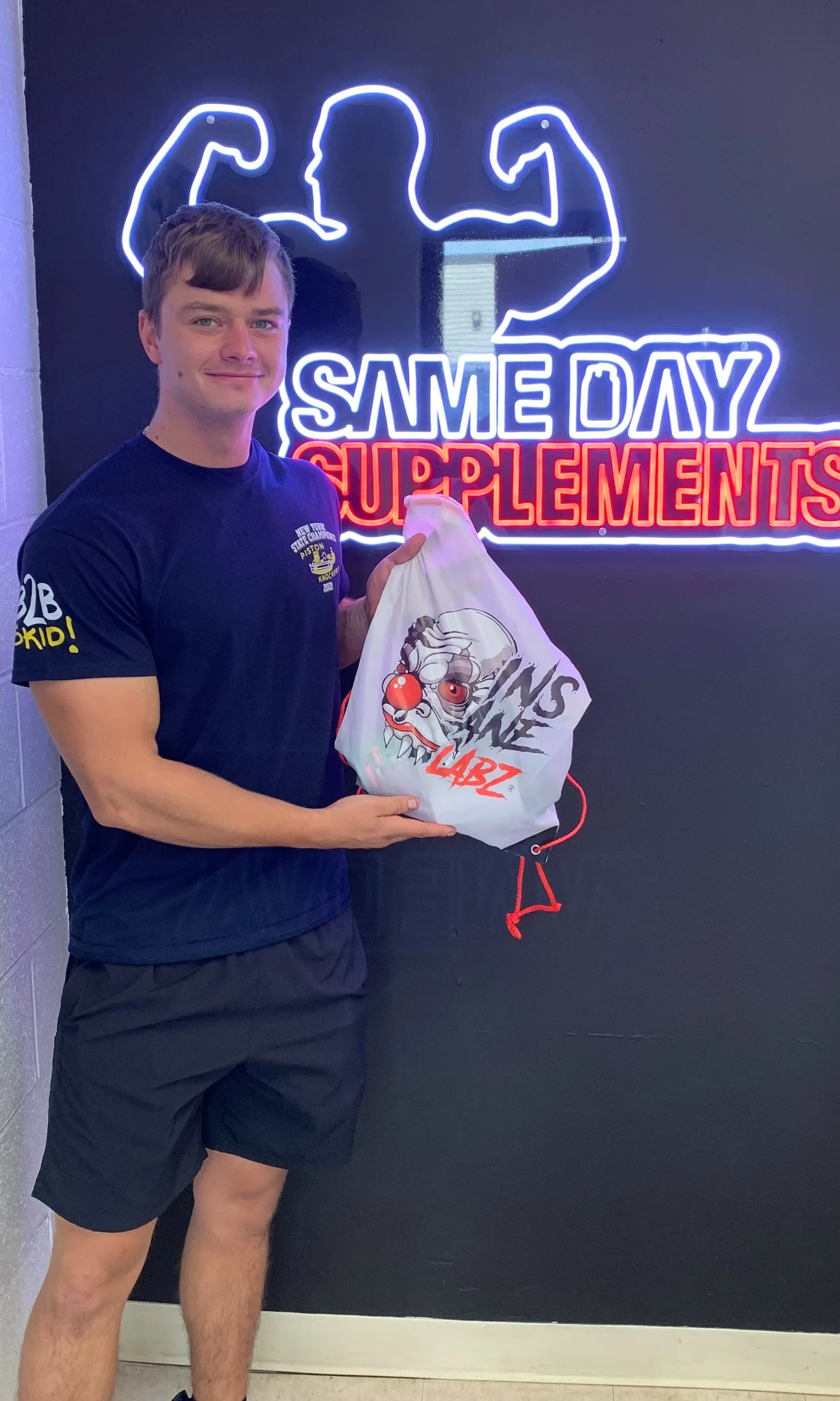 Customer with Insane Labz gift bag at pickup station