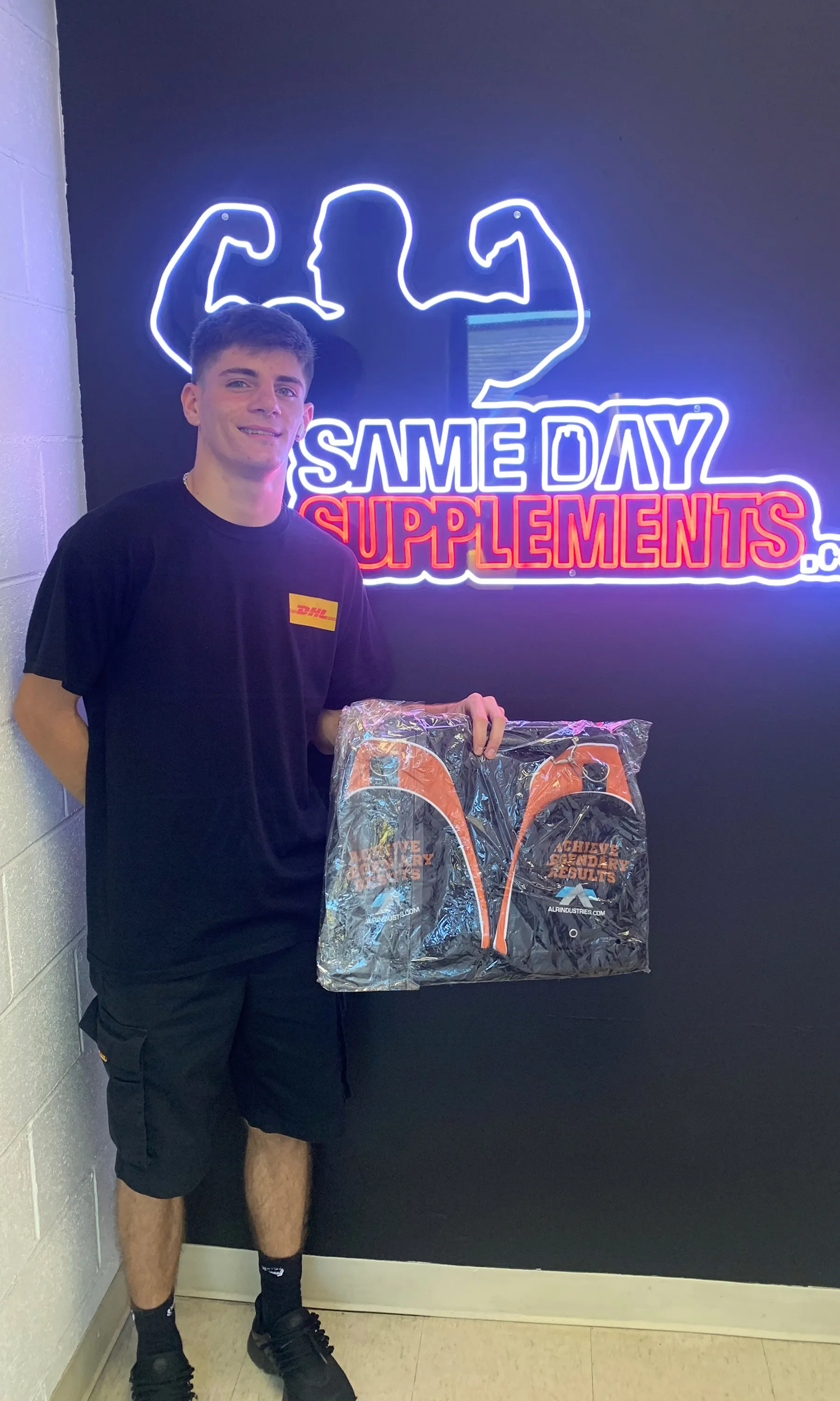 Customer in DHL shirt holding Arms Race bundle